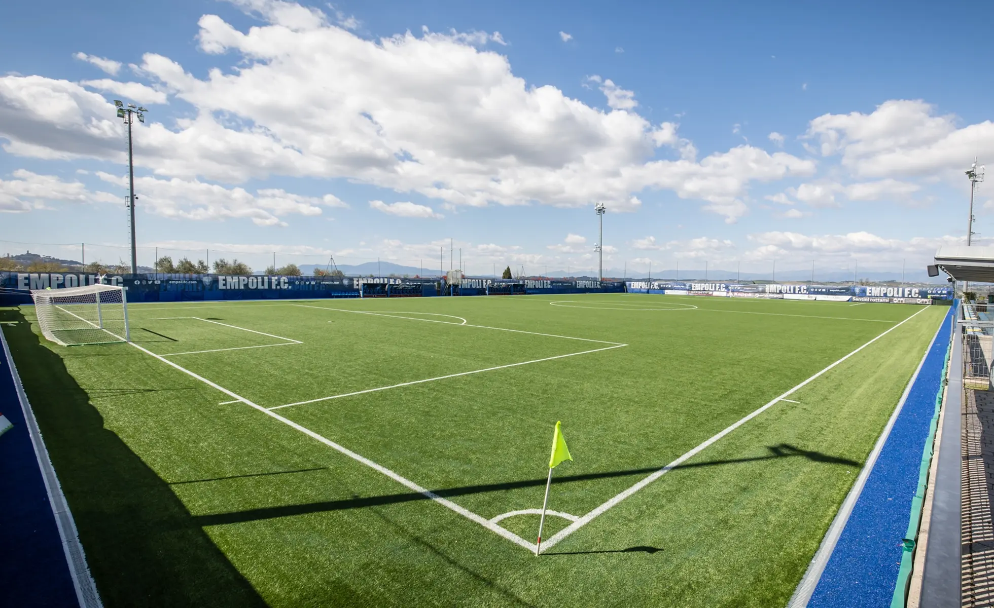 Campo da calcio visto dal lato della bandierina con installazione di erba sintetica verde.