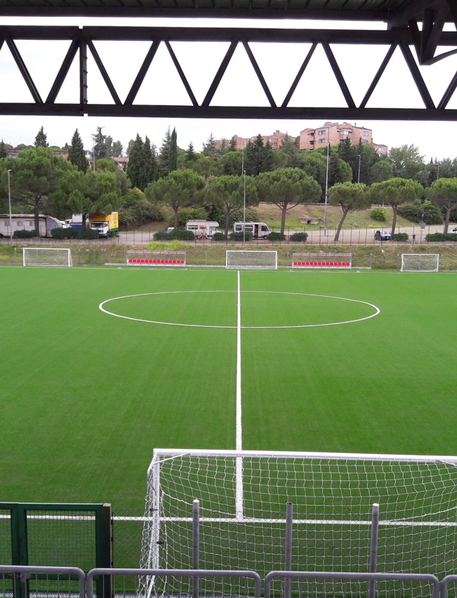 Vista del campo da calcio con erba sintetica dagli spalti