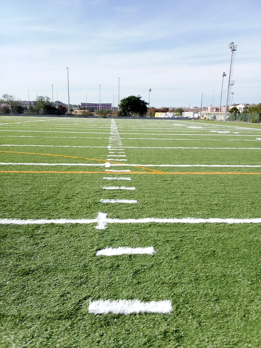 Dettaglio del campo di football americano con l'installazione di erba sintetica