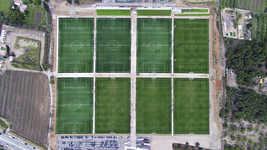 Veduta dall'alto del complesso sportivo con campi composti da erba sintetica.