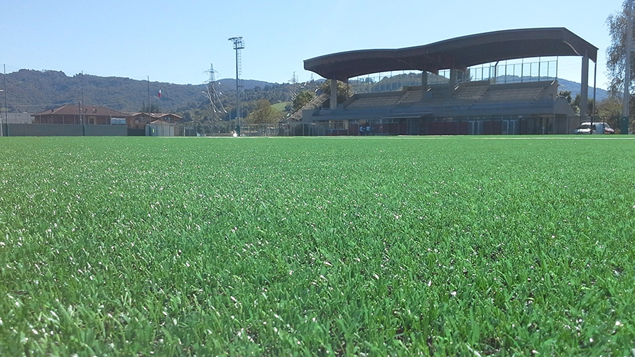 Campo da calcio con installazione di erba sintetica con vista sugli spalti. 