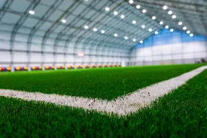 Primo piano di prato sintetico per calcio con fibre verdi e intaso tecnico