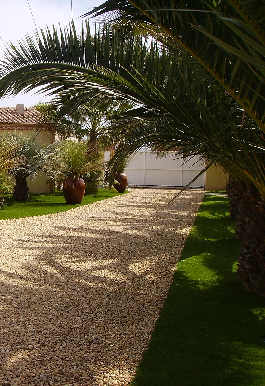 Viale di ghiaia in un giardino privato con erba sintetica
