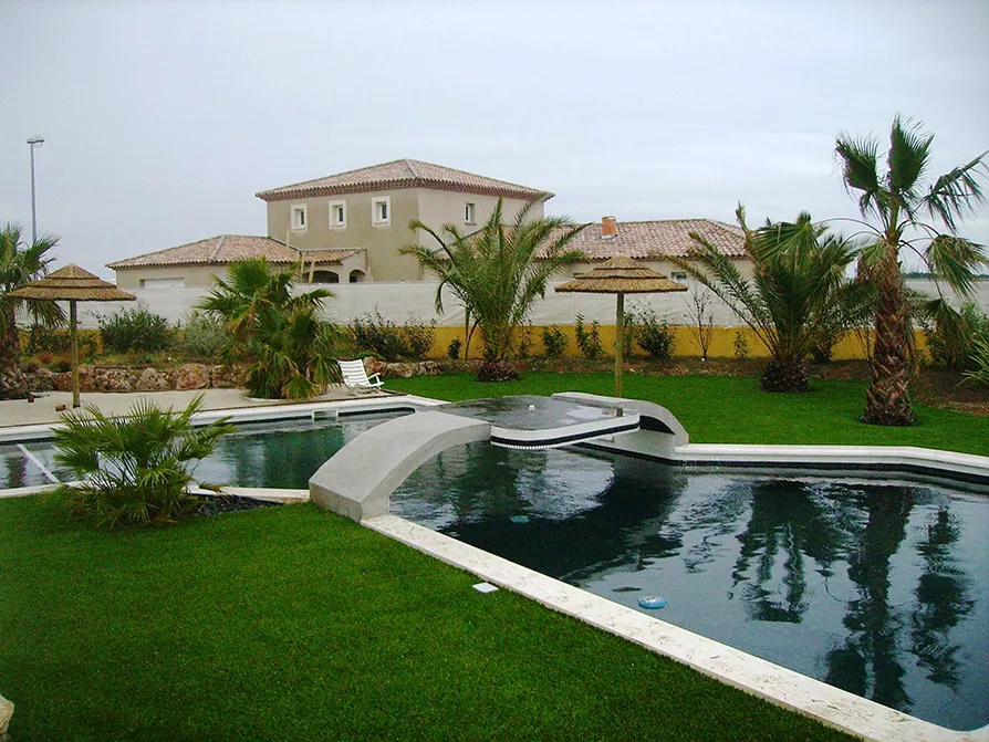 Villa privata con piscina in un giardino composto da erba sintetica.