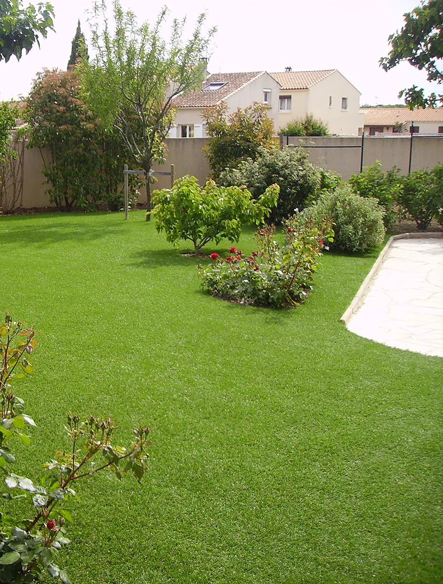 Giardino di erba sintetica con piante.